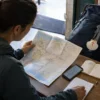 A pilgrim reviewing route notes and a Camino credential before the Porto to Vila do Conde stage.