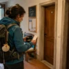 A pilgrim comparing budget notes, route information and a Camino credential before walking from Porto to Santiago.